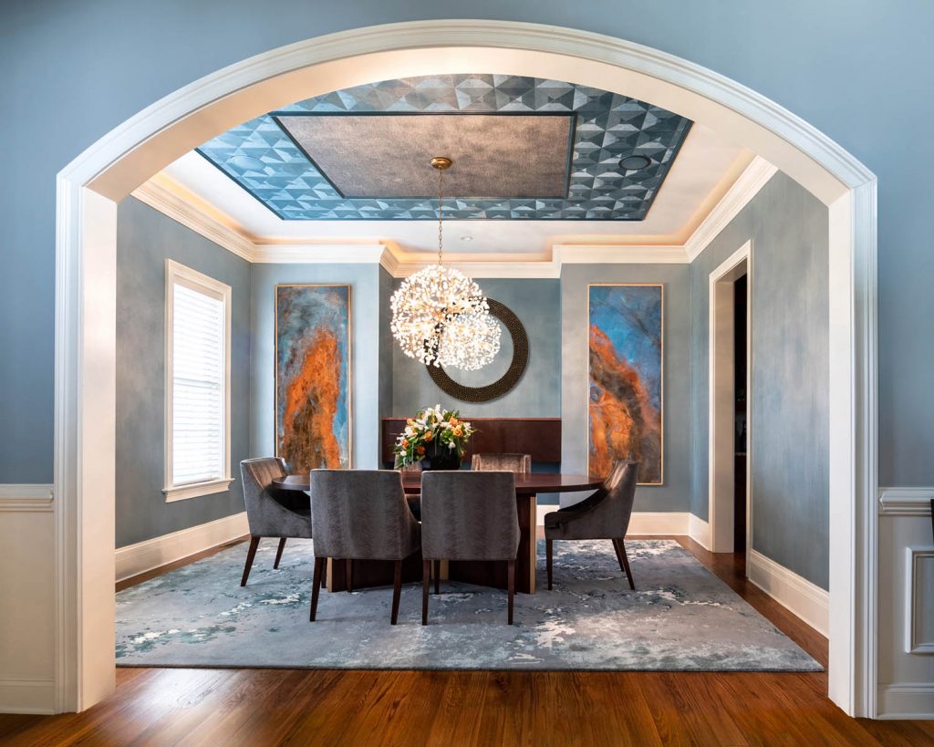Dining room with chandelier, artwork framing the entry, and exquisite ceiling details.