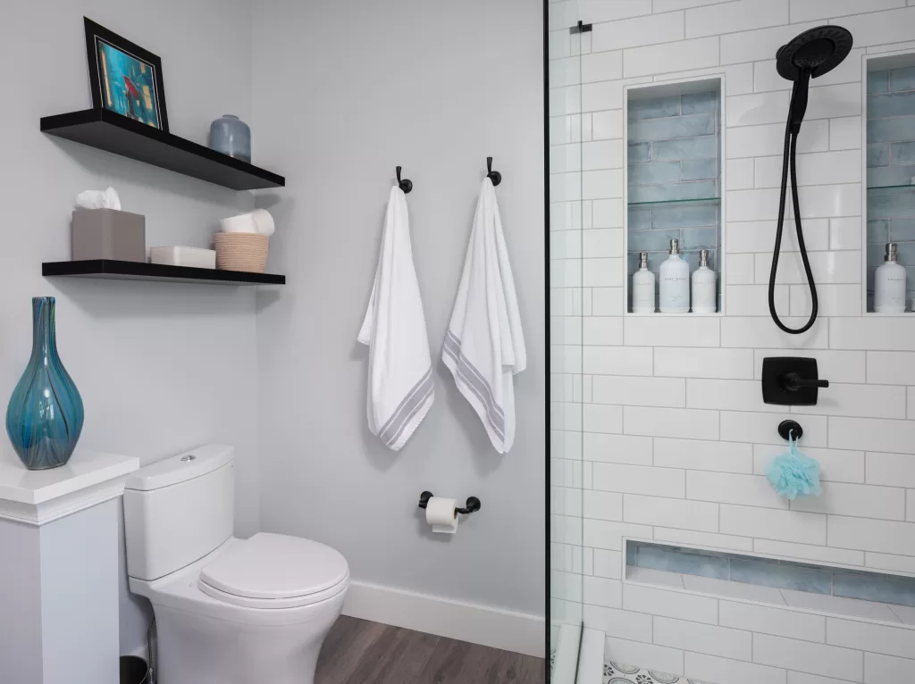 photo of bathroom with towel hooks, floating shelve and stand up shower