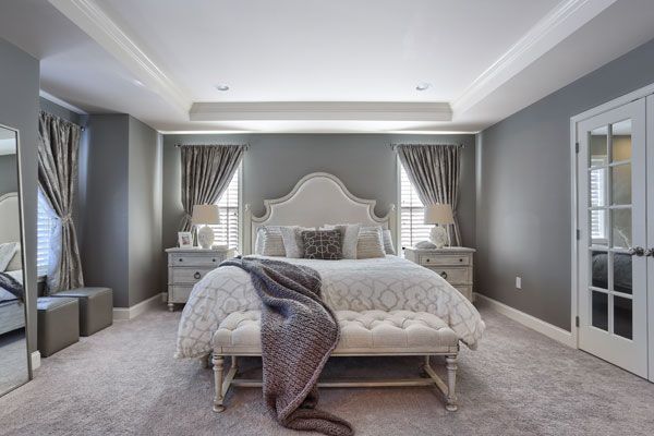 Bedroom with curved headboard, thick drapes that enhance the room.
