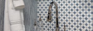 laundry room close up of single handle sink faucet with white and blue diamond pattern backsplash
