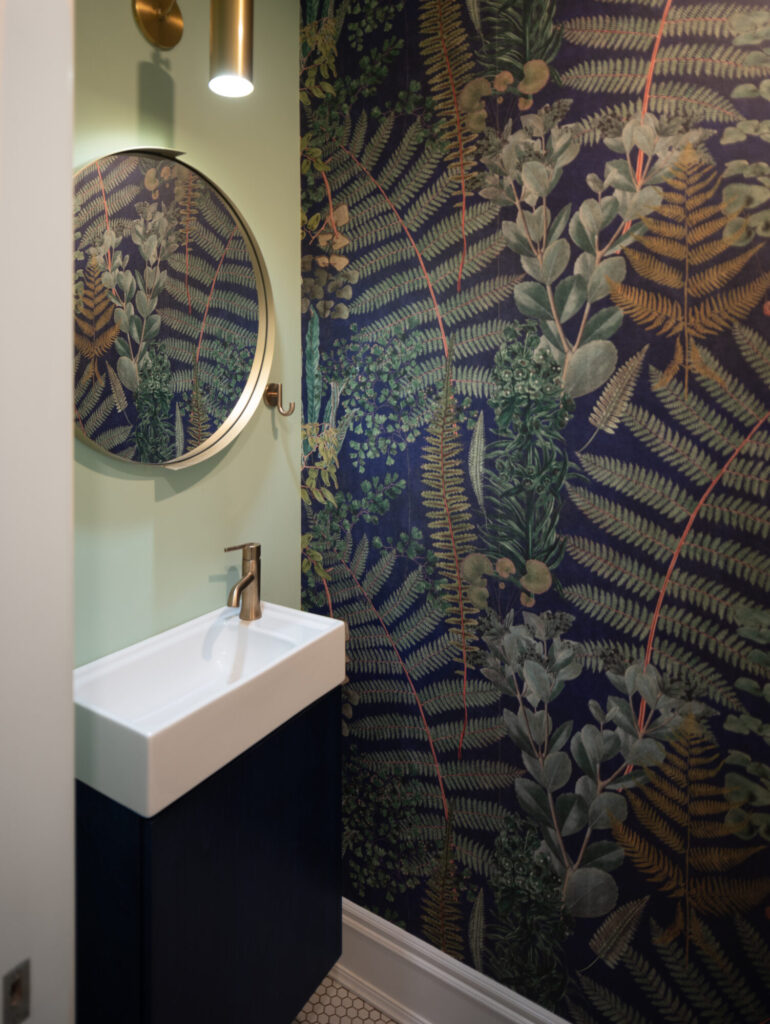 Fun foliage wallpaper in the compact powder room.