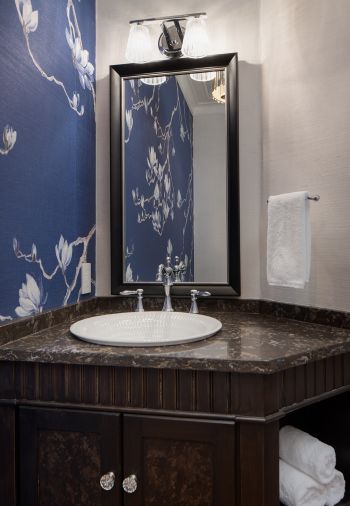 small powder room with elegant design, blue and white floral wallpaper, faux painted ceiling, chandelier, custom vanity