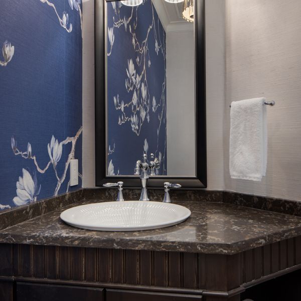 small powder room with elegant design, blue and white floral wallpaper, faux painted ceiling, chandelier, custom vanity