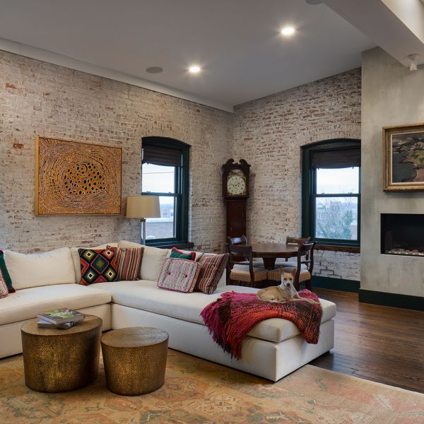 white couch, whitewashed brick wall, dark trim, dog on couch