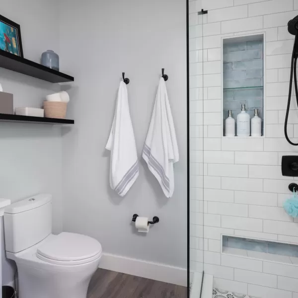 photo of bathroom with towel hooks, floating shelve and stand up shower
