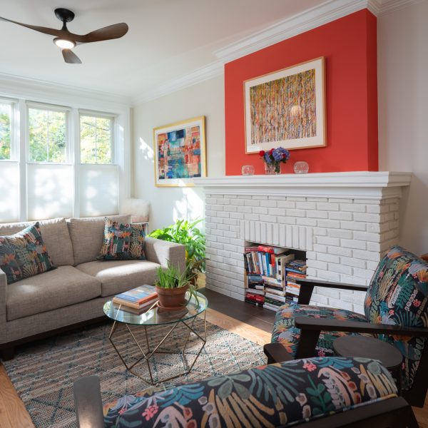 Living room with conversational seating with a brick fireplace.