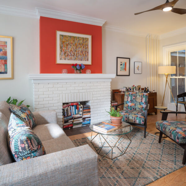 Living room with white brick fireplace, with a bright color on top.